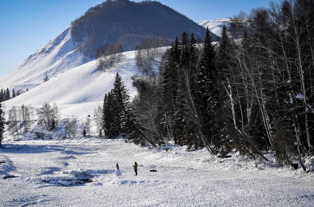 2024年2月5日，兩名游客在新疆阿勒泰地區(qū)布爾津縣禾木村拍照。新華社記者 馬鍇 攝