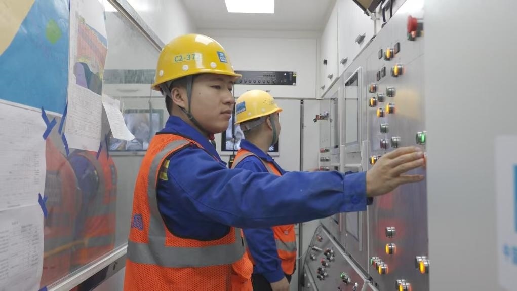 盾構(gòu)司機(jī)何曉波在駕駛室內(nèi)調(diào)試盾構(gòu)機(jī)參數(shù)。（劉芬攝）