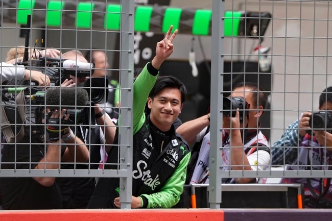 2024年4月19日，索伯車(chē)隊(duì)中國(guó)車(chē)手周冠宇（中）在練習(xí)賽前向觀(guān)眾致意。當(dāng)日，F(xiàn)1中國(guó)大獎(jiǎng)賽在上海開(kāi)賽。中國(guó)車(chē)手周冠宇主場(chǎng)首秀參賽。新華社記者 夏一方攝