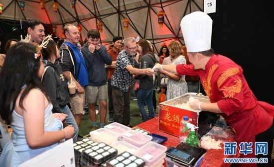 圖為游客在燈節(jié)現(xiàn)場購買小吃。（圖片由奧克蘭中國文化中心提供）
