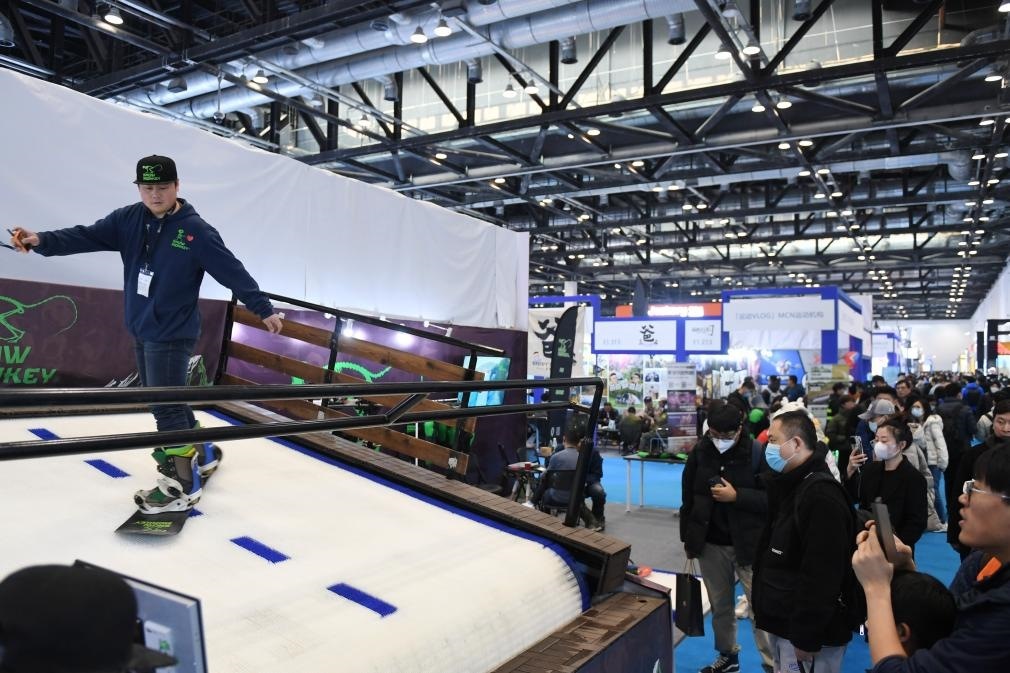 2023年2月11日，參觀者在展會(huì)上了解一款模擬滑雪設(shè)備。當(dāng)日，2023亞洲運(yùn)動(dòng)用品與時(shí)尚展在國(guó)家會(huì)議中心拉開(kāi)帷幕。新華社記者 張晨霖 攝