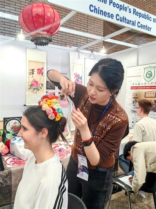 展覽正值羅馬尼亞迎春花節(jié)，國際中文教師志愿者潘婧穎向游客們介紹了國家非物質(zhì)文化遺產(chǎn)——福建泉州的簪花文化。布加勒斯特大學(xué)孔子學(xué)院供圖。