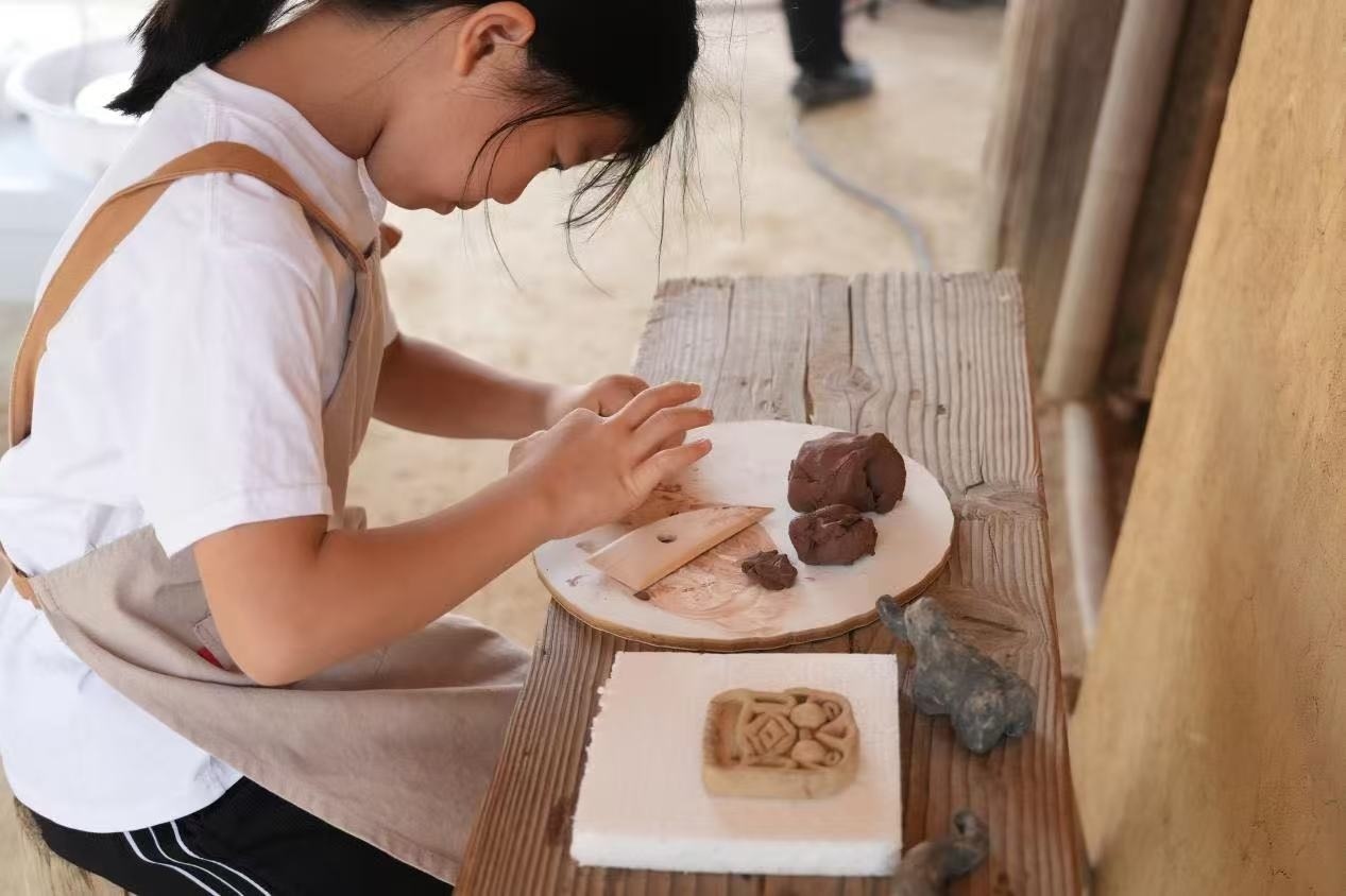 游客制作良渚特色陶藝品。良渚博物院供圖