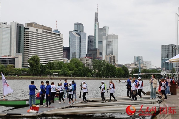 來自美國的快樂龍舟隊(duì)選手們正在登船準(zhǔn)備參賽。人民網(wǎng)記者 劉仲華攝